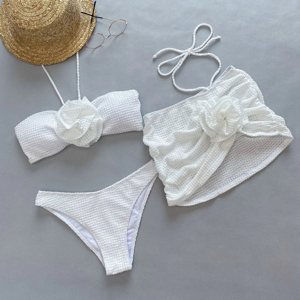 Women's purple three-piece bikini set with 3D flower split detail on a white background