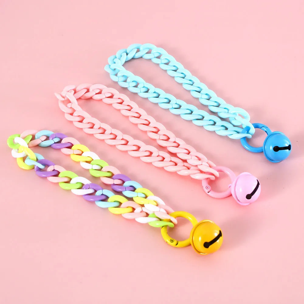 Adjustable plastic pet collar in macaron candy colours on a table, showing chain blue, pink, and mixed colour variants.