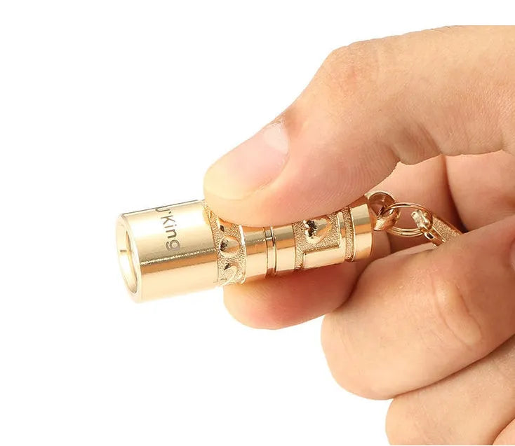 Gold-coloured zinc alloy waterproof mini LED keychain flashlight on a keyring.