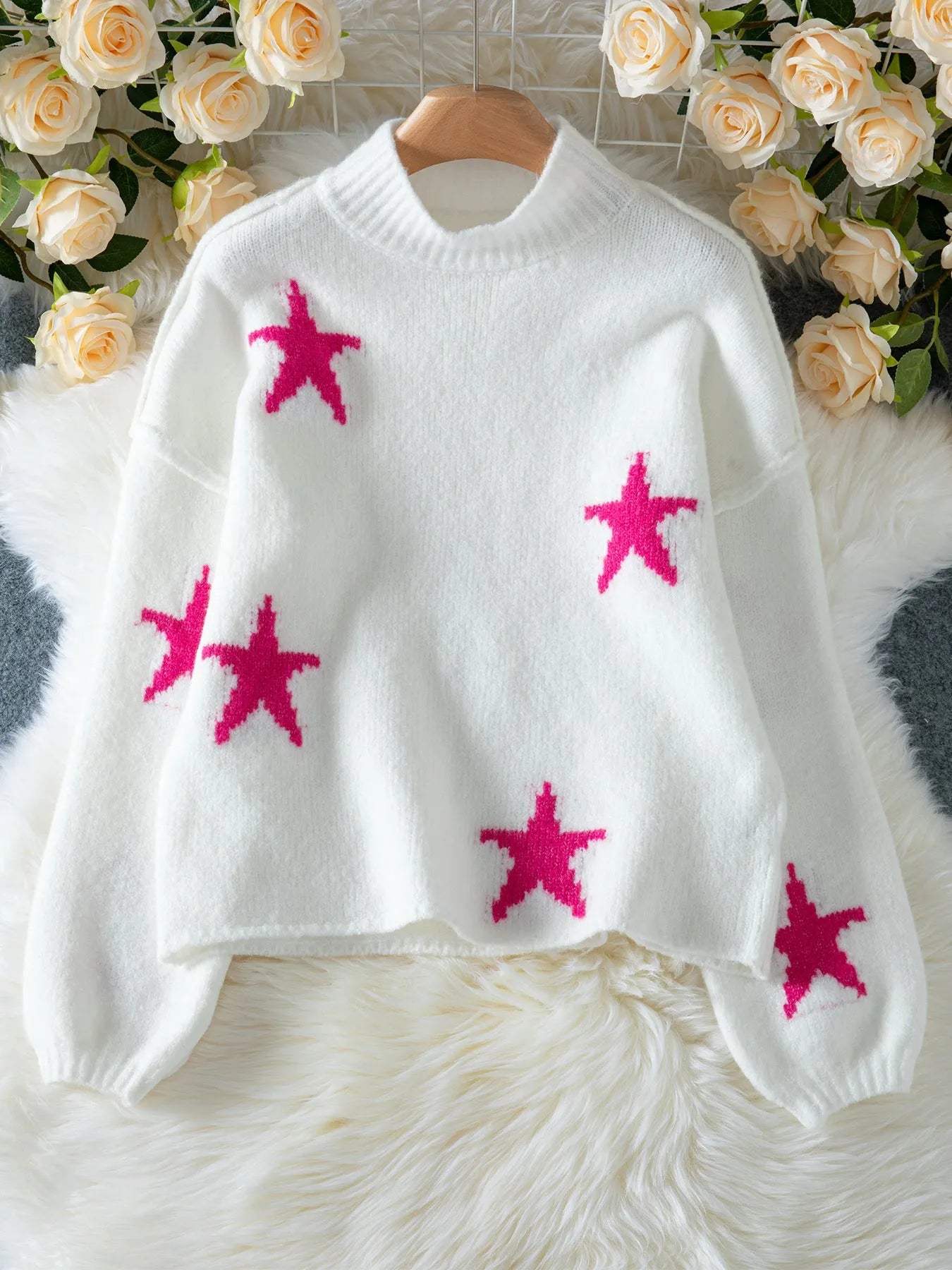 White women's turtleneck pullover sweater with a black five-pointed star pattern on the front.