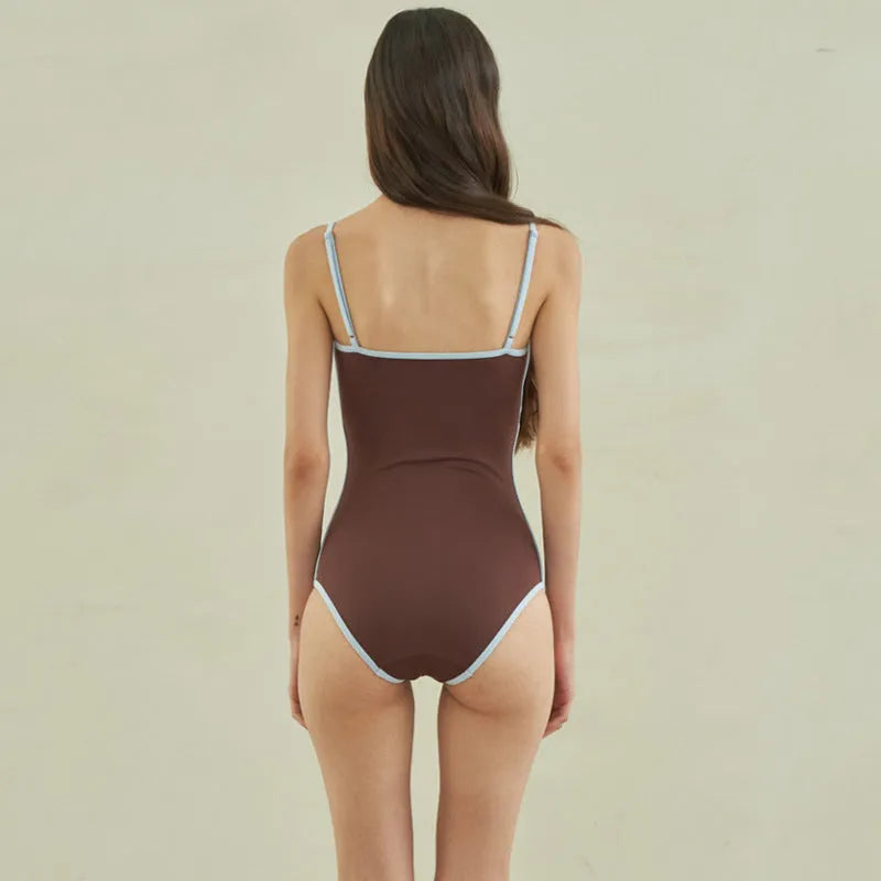 Brown women's one-piece triangle swimsuit on a hanger, showing front design.