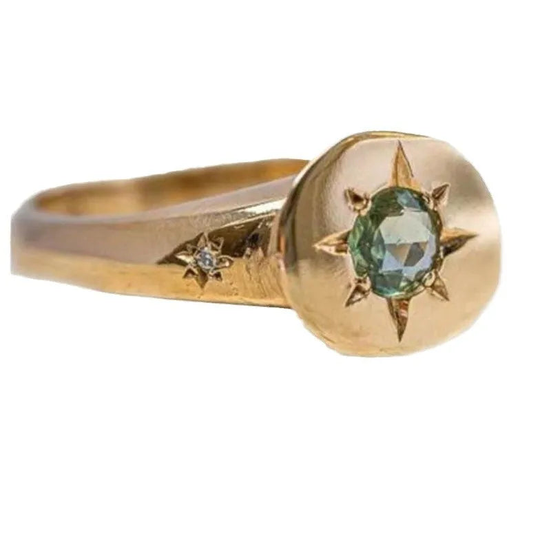 Gold coloured adjustable ring with a star-shaped zircon centre on a zinc alloy band.