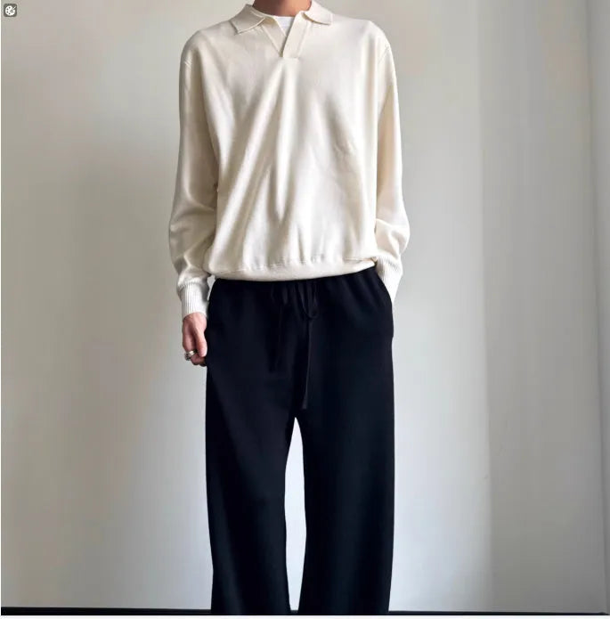 Man wearing a milky white pure wool polo sweater with a lapel collar.