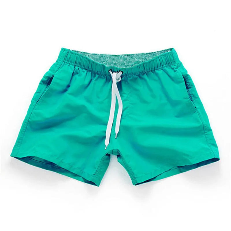 Men's straight-leg beach shorts in black polyester fabric on a size chart.