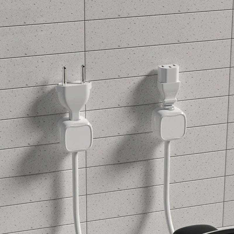 Magnetic cable clip in white holding a USB cable under a desk, with adhesive backing visible