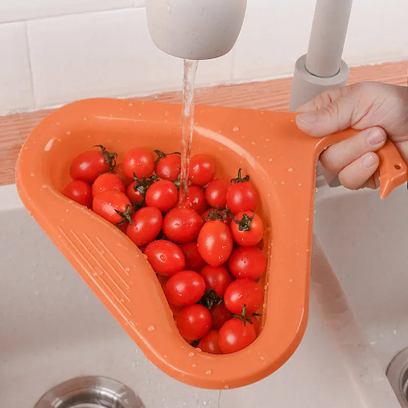 Household sink hanging fruit and vegetable drain basket in green plastic, clipped onto sink rim with slotted base