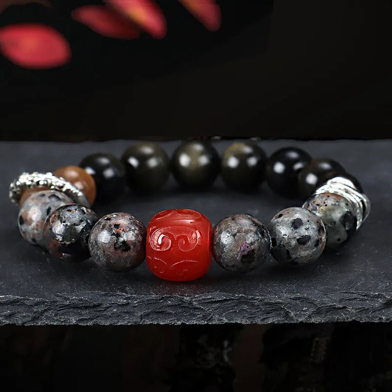Gold obsidian flame stone and red agate unisex bracelet with original Wukong design on neutral background