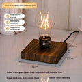 Small black suspension bulb night lamp with iron art body on a wooden base.