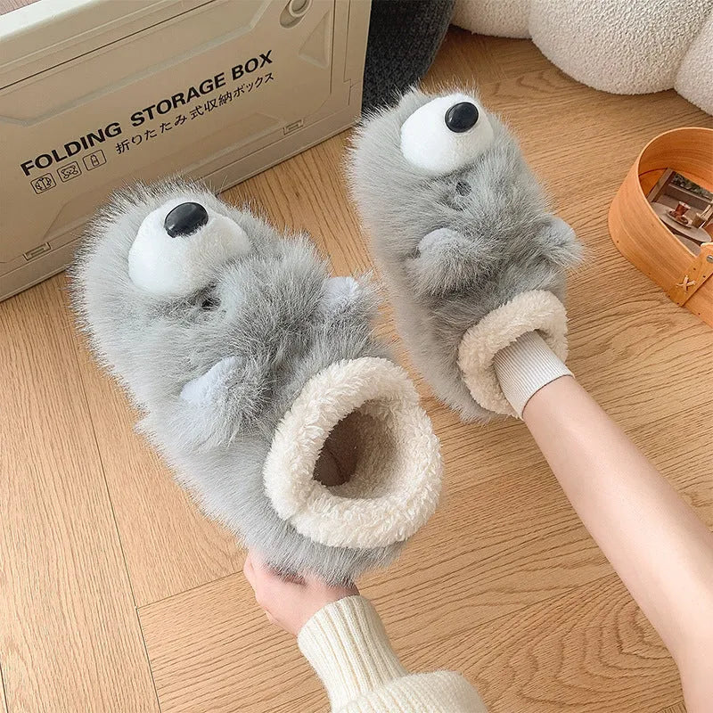 Pair of grey ankle wrap cotton slippers with plush upper and artificial wool lining on a home floor