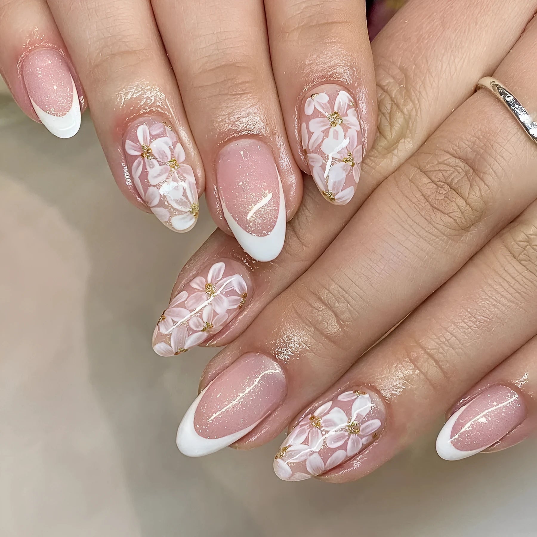 Short almond false nails with French manicure style and glittering floral powder accents in C625 colour