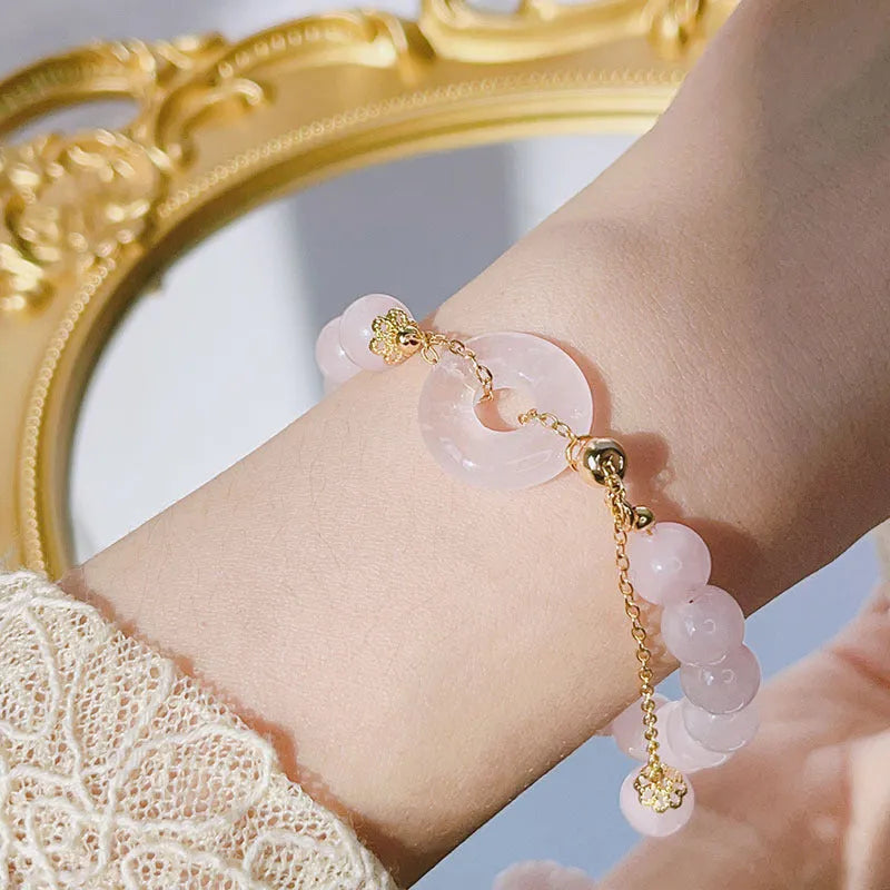 Crystal safety buckle bracelet for women in pink with peace buckle design on white background