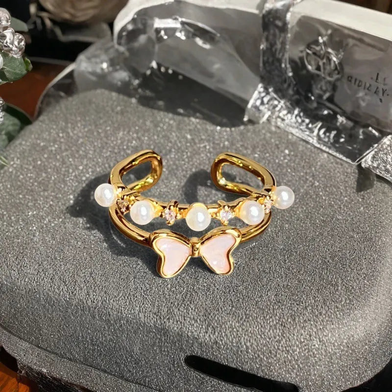 Adjustable copper ring with vintage oil dripping gourd, flower, and bow design and inlaid zircon stones.