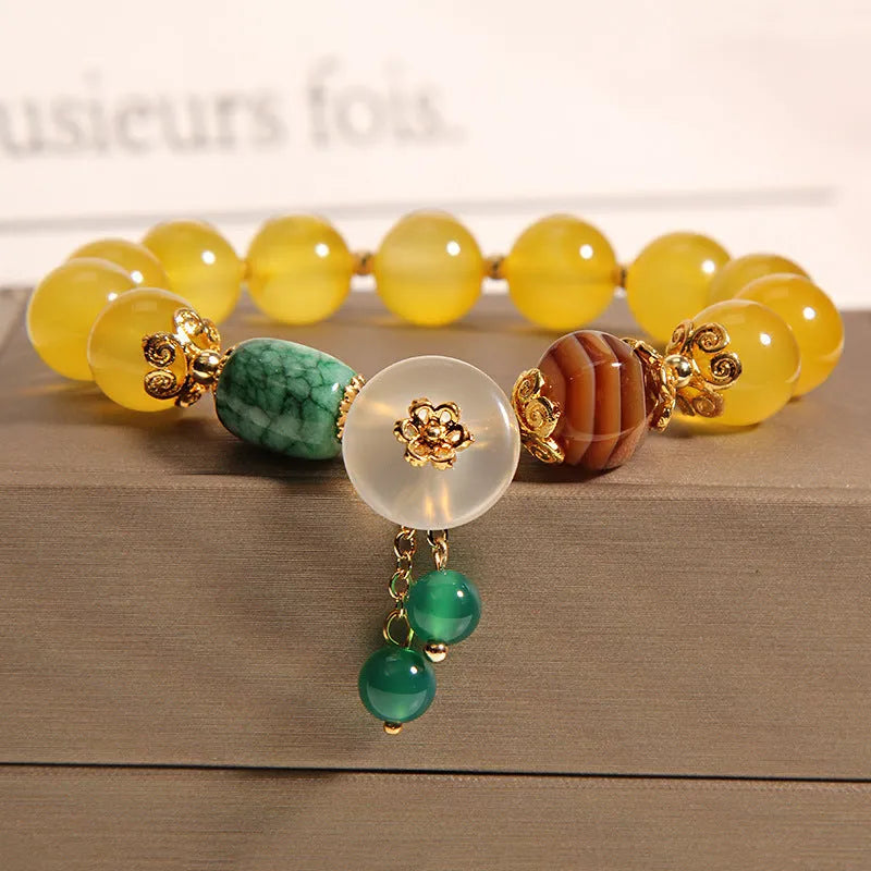 Women's yellow agate crystal bracelet with adjustable gold silk cord on wrist