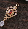 Silver tone crown motif hollow water drop copper pendant in five colours, measuring 12mm by 23mm.