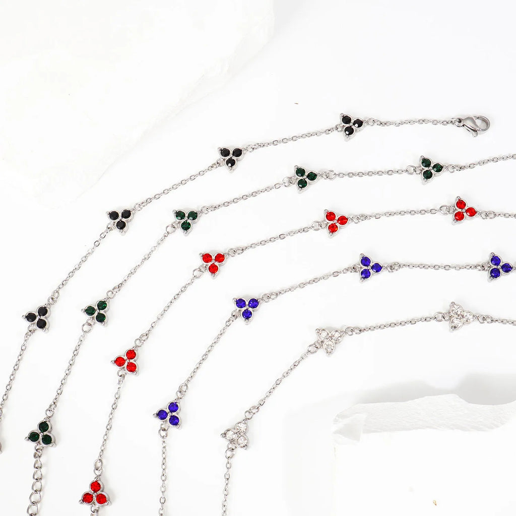 Geometric stainless steel women's bracelet with three diamond shapes and coloured stone settings.
