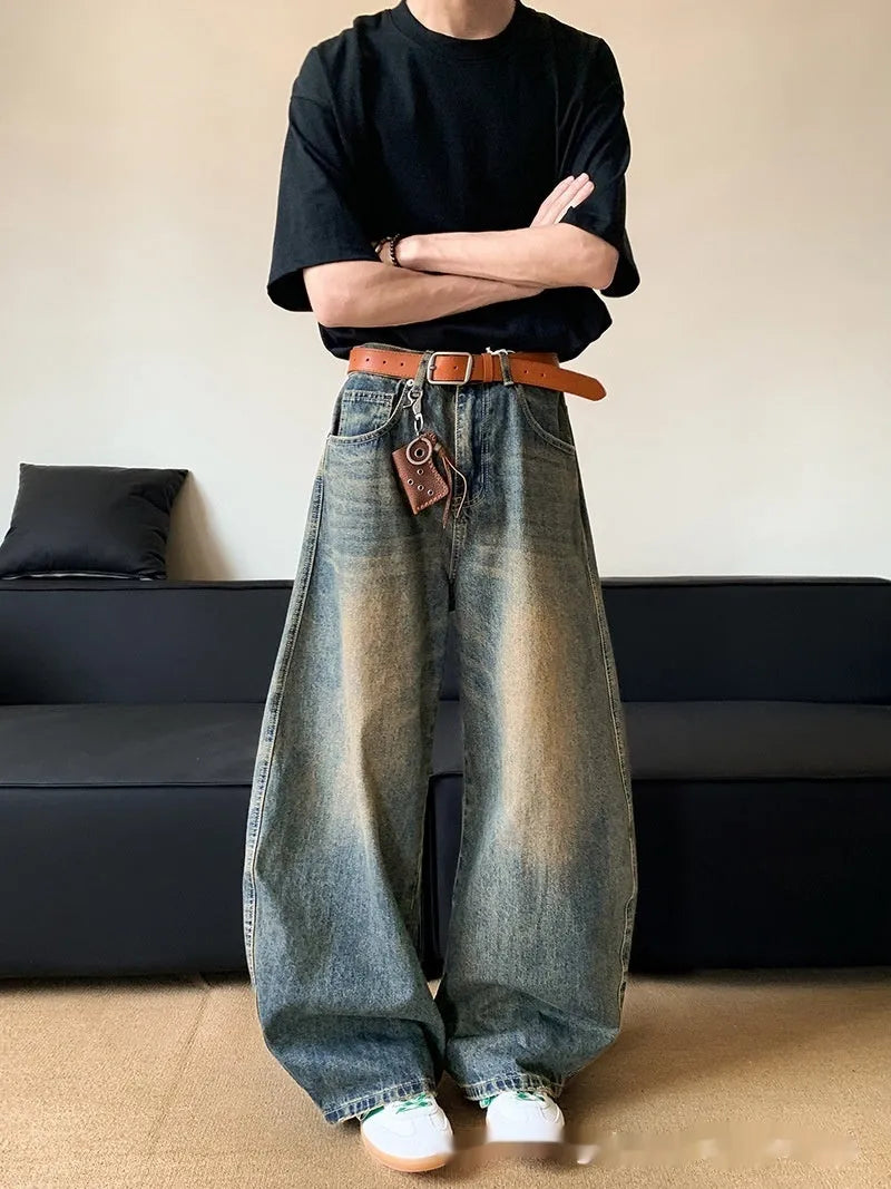 Man wearing retro blue distressed denim wide-leg trousers with a slim fit and zipper fly