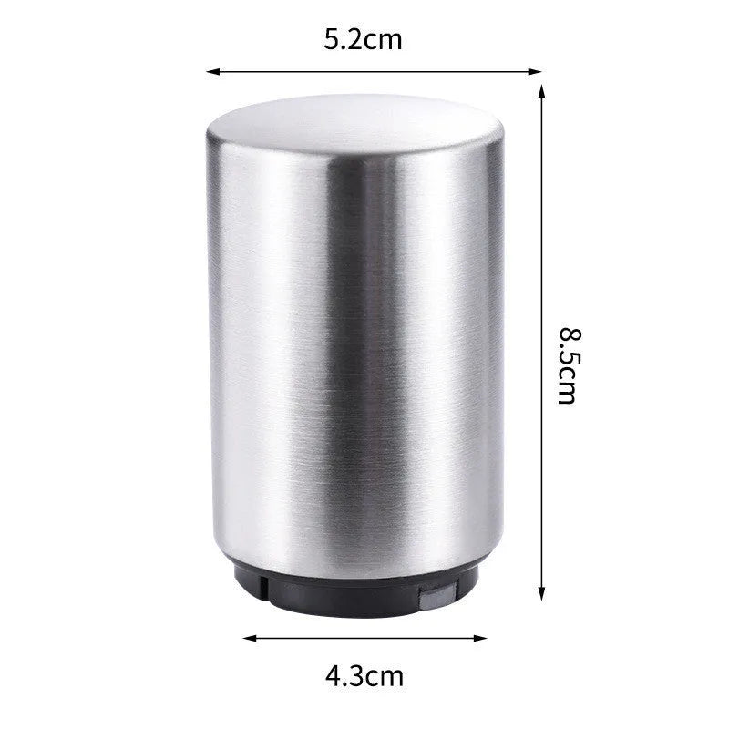 Automatic stainless steel beer bottle opener with magnetic cap catch on a table