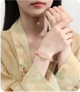 Gold 925 silver koi peace buckle bracelet with red rope on white background