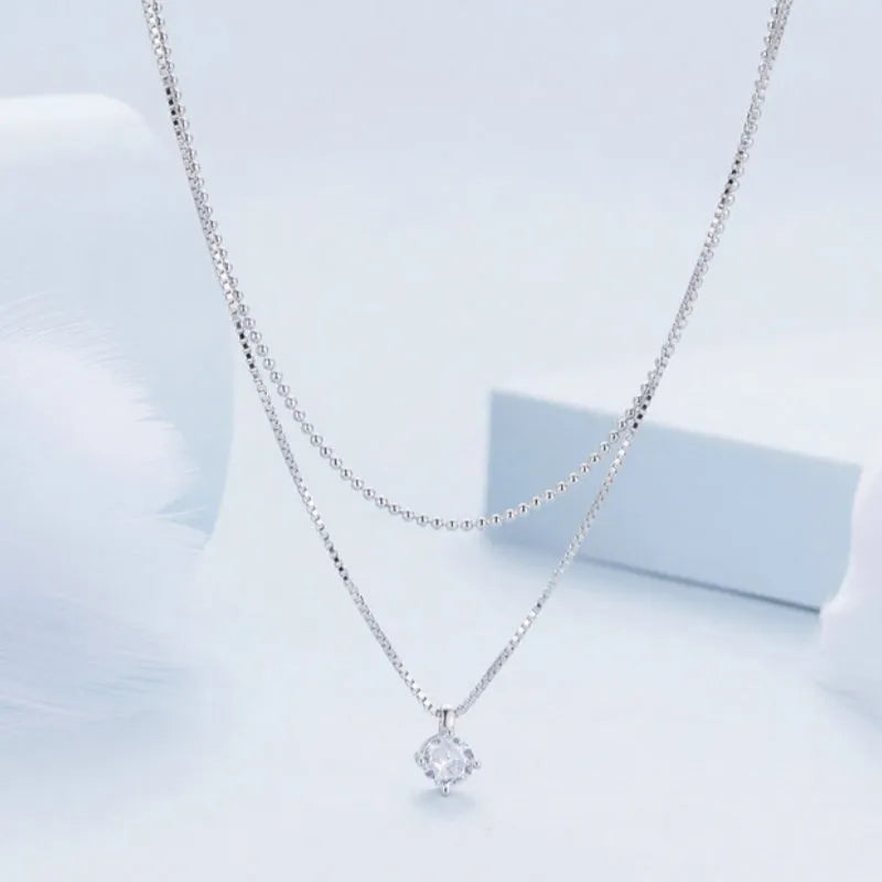 Silver double-layer necklace with pearl chain and sterling silver pendant.