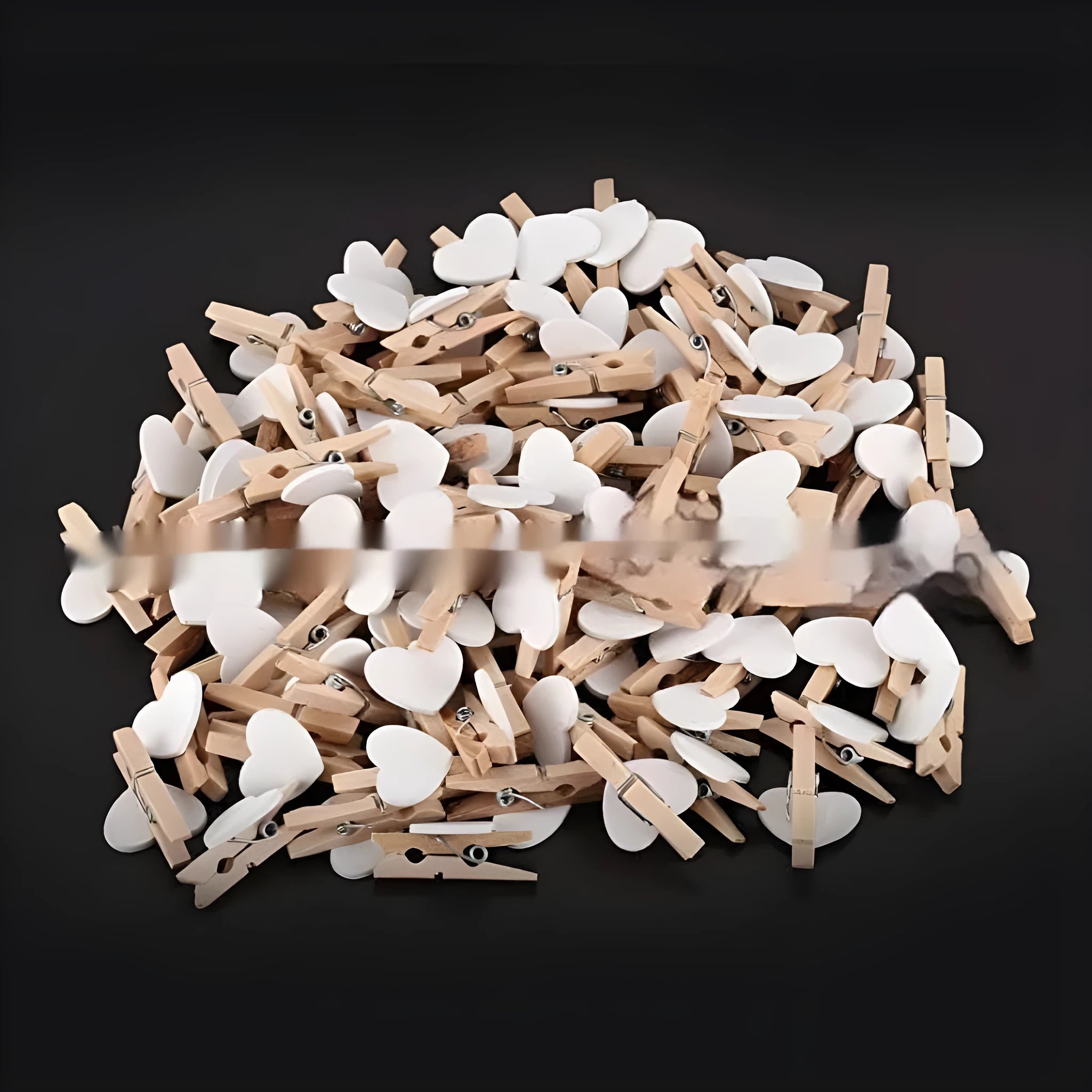 Five wooden heart-shaped clips in different colours on wooden surface
