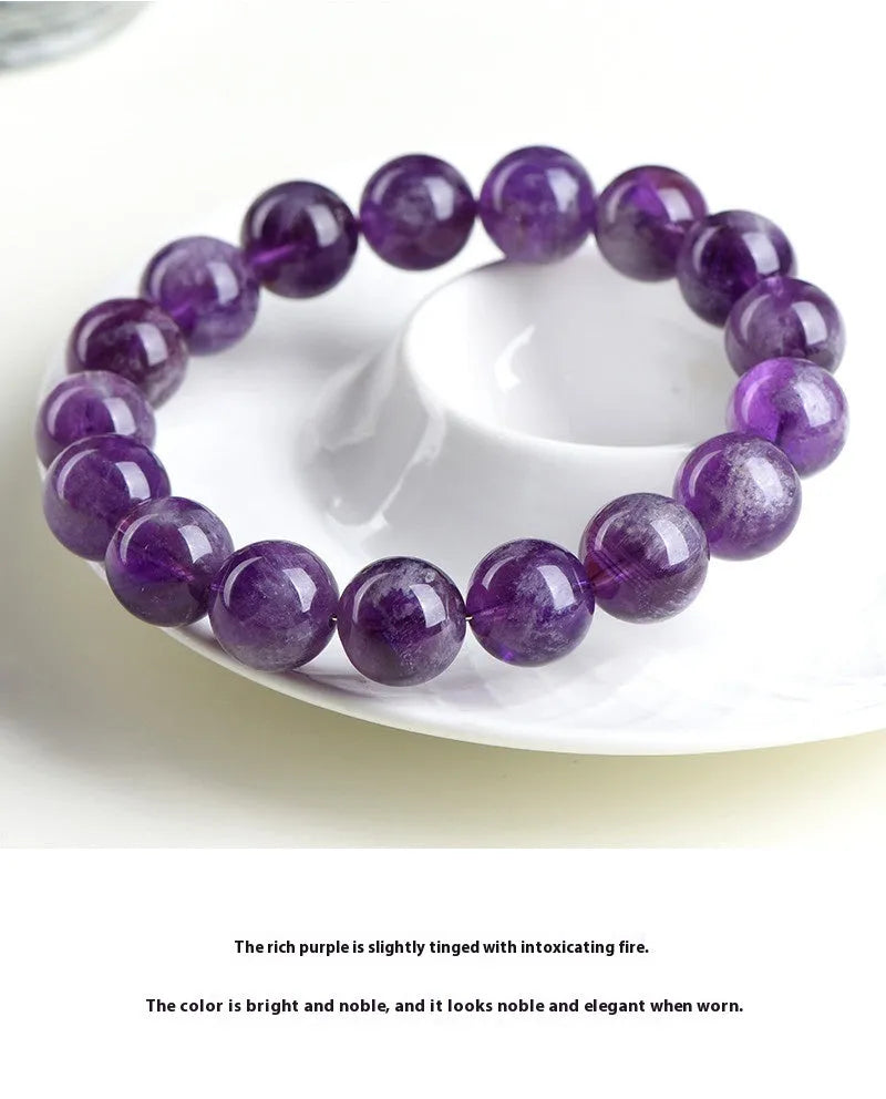 Natural purple feather amethyst crystal bracelet with scattered beads and geometric Ruyi pattern on a wrist.