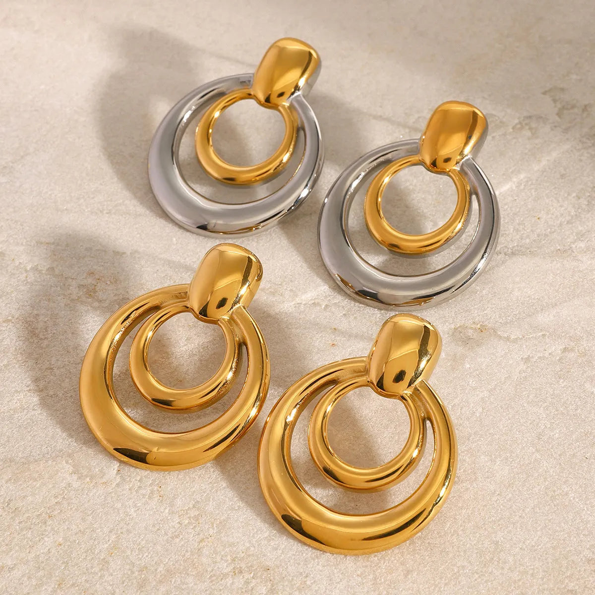 Golden double layer hollow stud earrings with geometric round shape and 18K gold electroplated finish