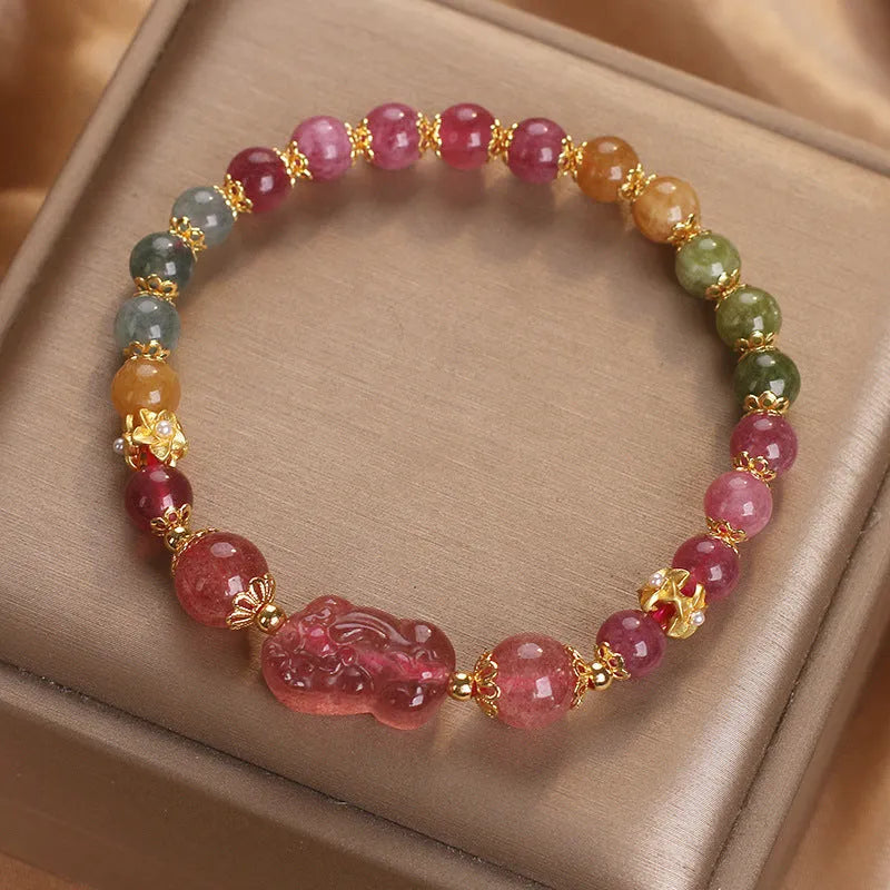 Pink crystal Pi Xiu bracelet with tourmaline and strawberry quartz beads on white background