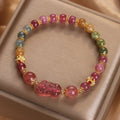 Pink crystal Pi Xiu bracelet with tourmaline and strawberry quartz beads on white background