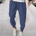 Men's loose cotton ankle banded trousers in khaki colour on a hanger.