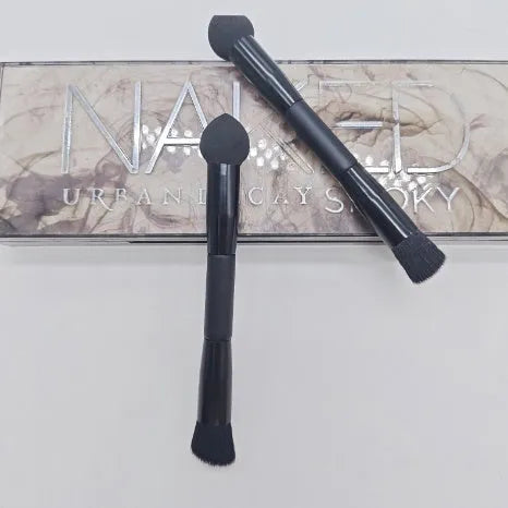 Double-headed black makeup brush with angled sponge and concealer brush on wooden handle