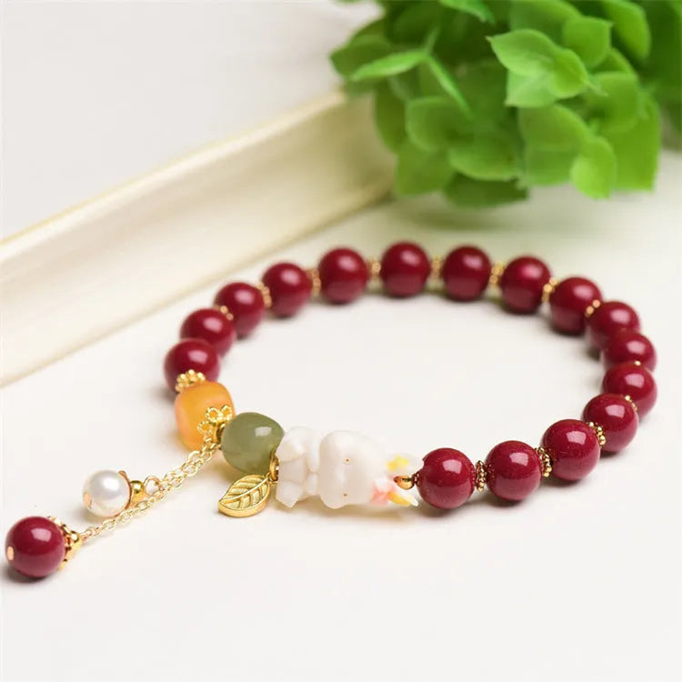 Women's bracelet with natural beeswax, purple gold sand beads, and a red cinnabar rabbit charm.
