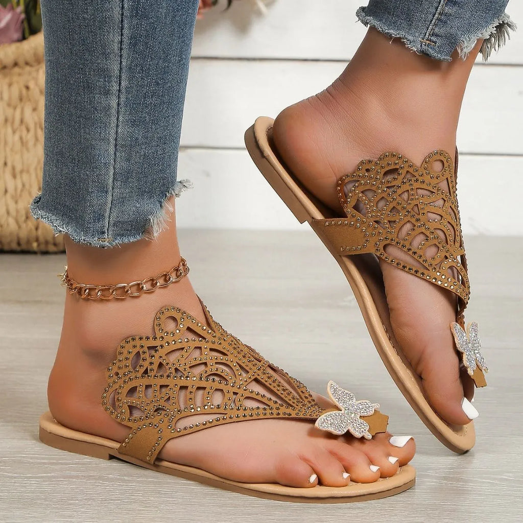 Gold women's slip-on sandals with rhinestone detail on the flip-toe strap and a flat rubber sole.