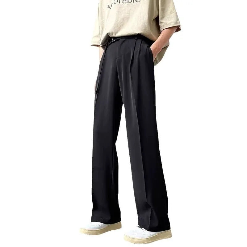 A pair of thin, straight-cut wide leg trousers in black on a hanger.