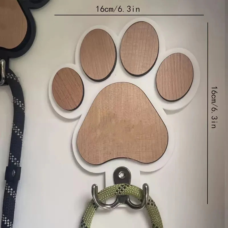 Wooden foot paw print hook in black colour on a white wall for household organisation