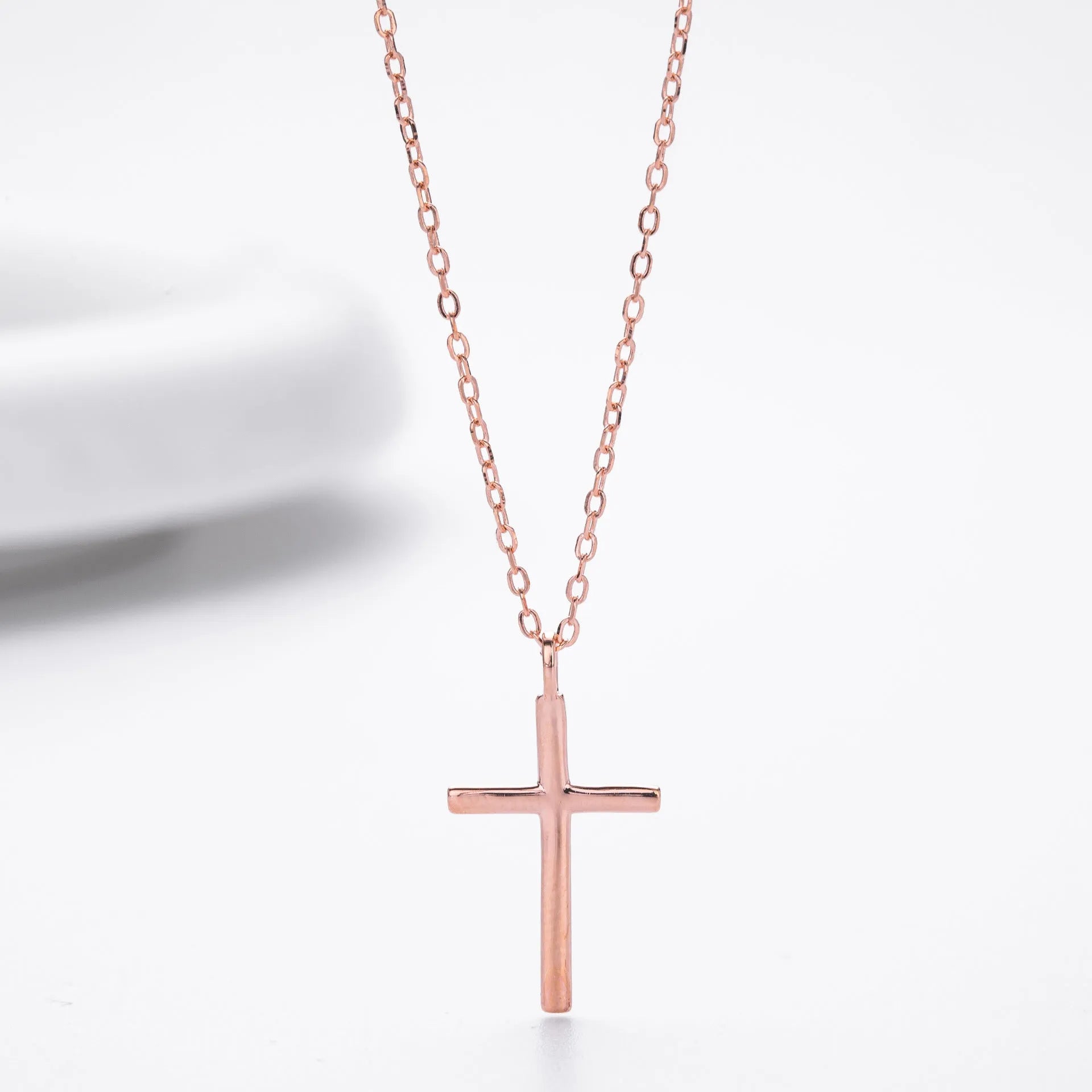 Simple glossy cross pendant on an O-chain sterling silver necklace in gold plating.