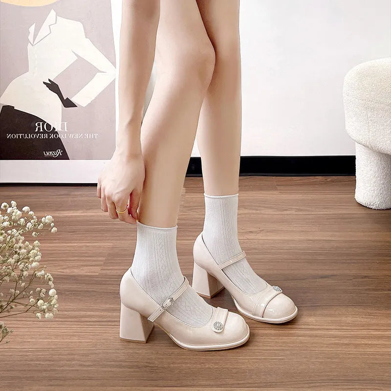 Women's black patent leather wide fit high heels with a round toe and chunky heel.