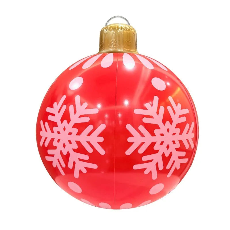 Large red inflatable Christmas ball with flash LED lights in a snowy garden.