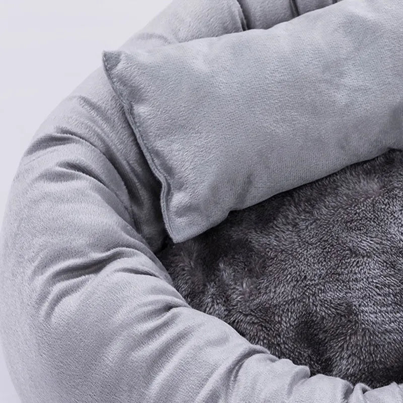 Round grey dog bed with fluffy rim and matching pillow on a non-slip Oxford cloth base.