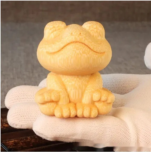 Solid bamboo carved ornament of a smiling cartoon frog, 5cm tall.