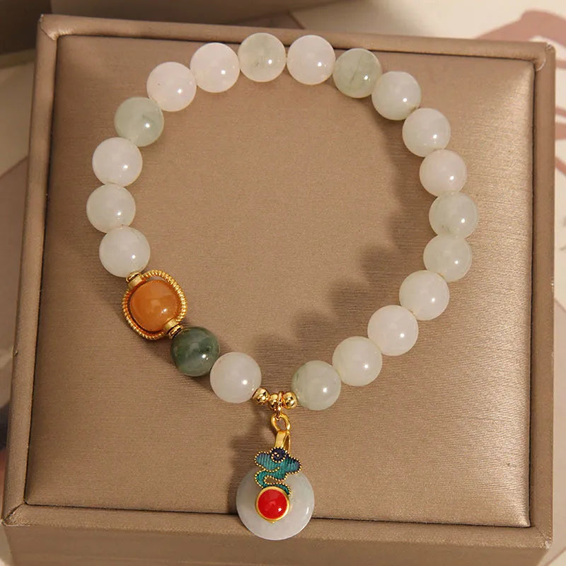 Women's ice jade bracelet with pearl accents and a Xiangyun jade buckle on a wrist.