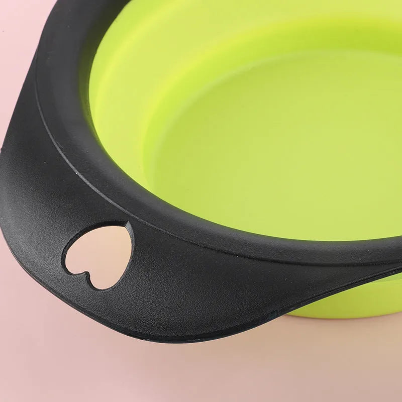 Silicone folding bowl for pets in black and green, collapsed flat for storage, portable outdoor cat and dog food bowl