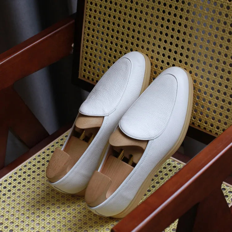 British handmade brown leather loafers for men on a white background.