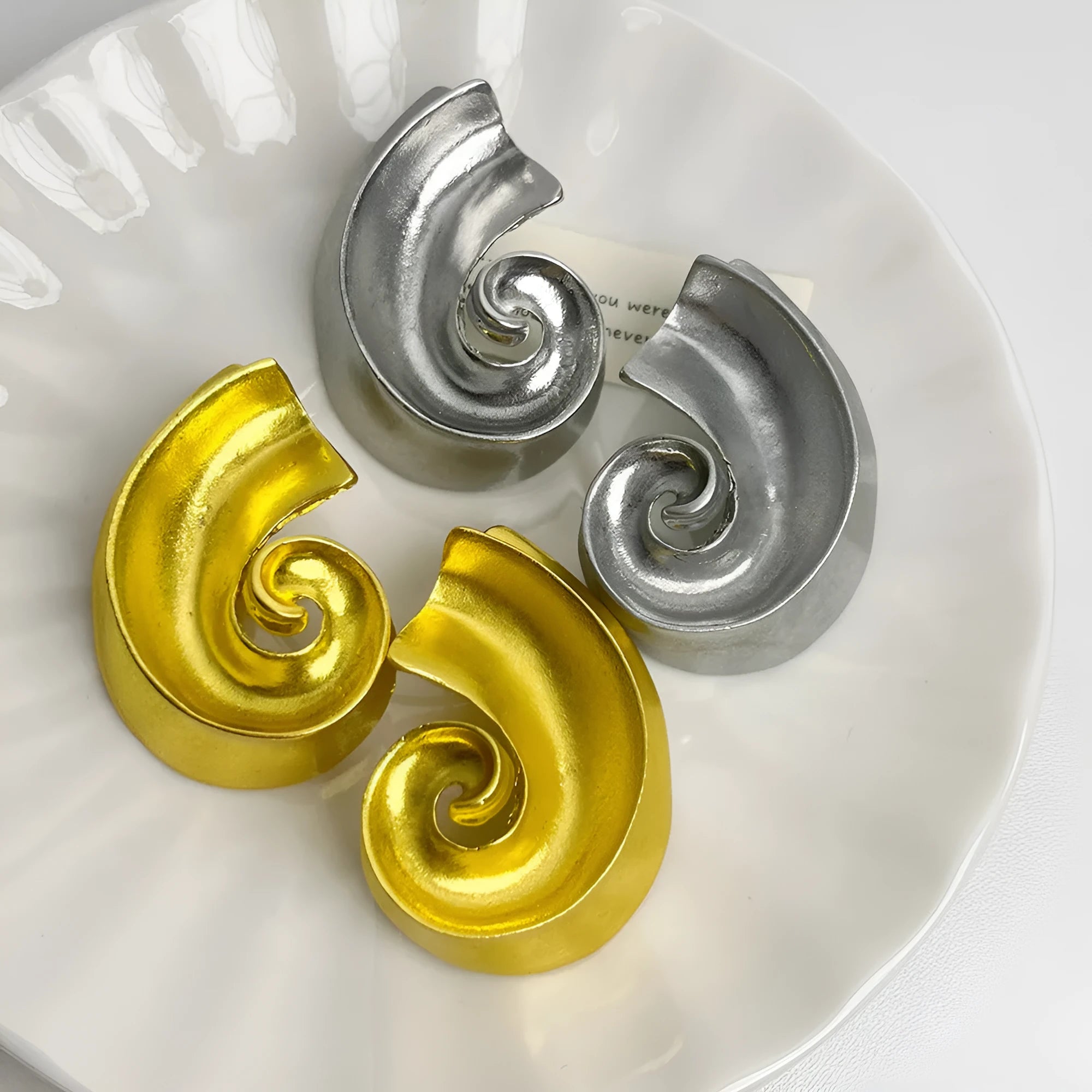 A pair of geometric-shaped alloy ear studs with a retro design, shown in gold and silver colours on a post backing.