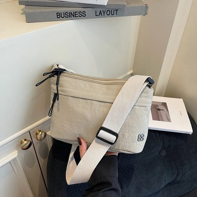 Lightweight cloth crossbody bag in black with horizontal square shape, sandwich pocket, and canvas lining
