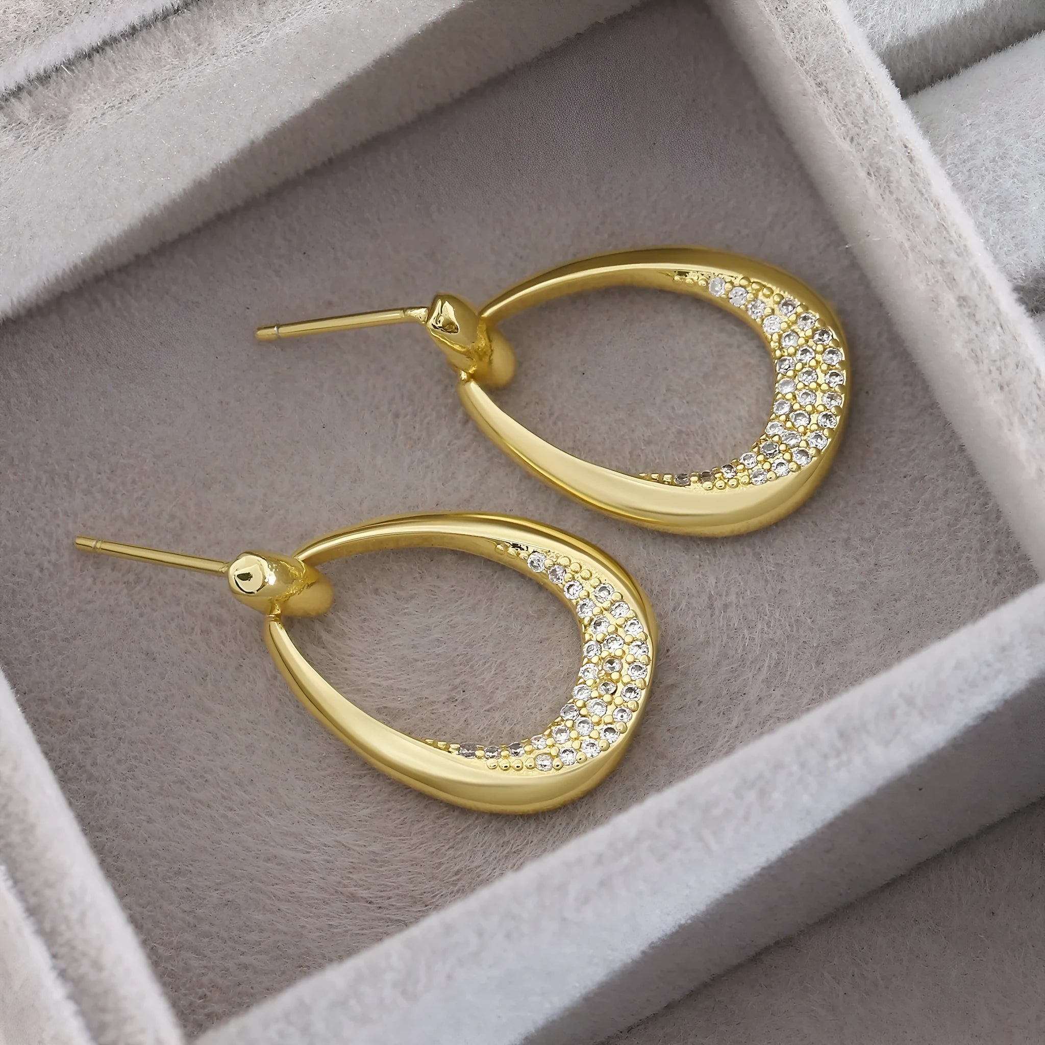 Women's yellow gold geometric drop earrings with simple zircon detail showing oval and round design elements