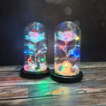 Gold artificial rose inside glass dome with LED lights on black base for home display