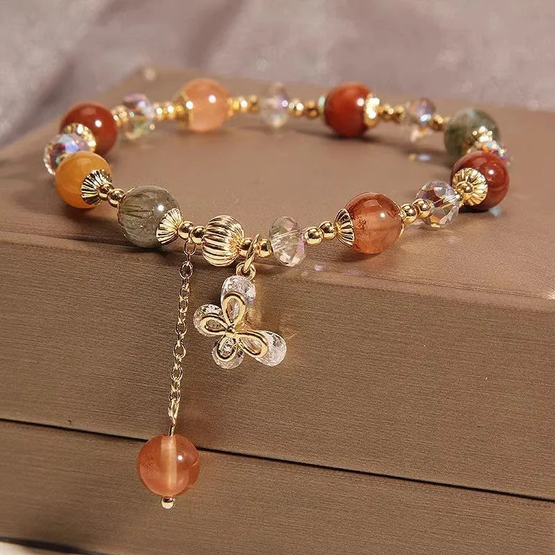 Single circle coloured hair crystal bracelet with zircon butterfly motif on light background