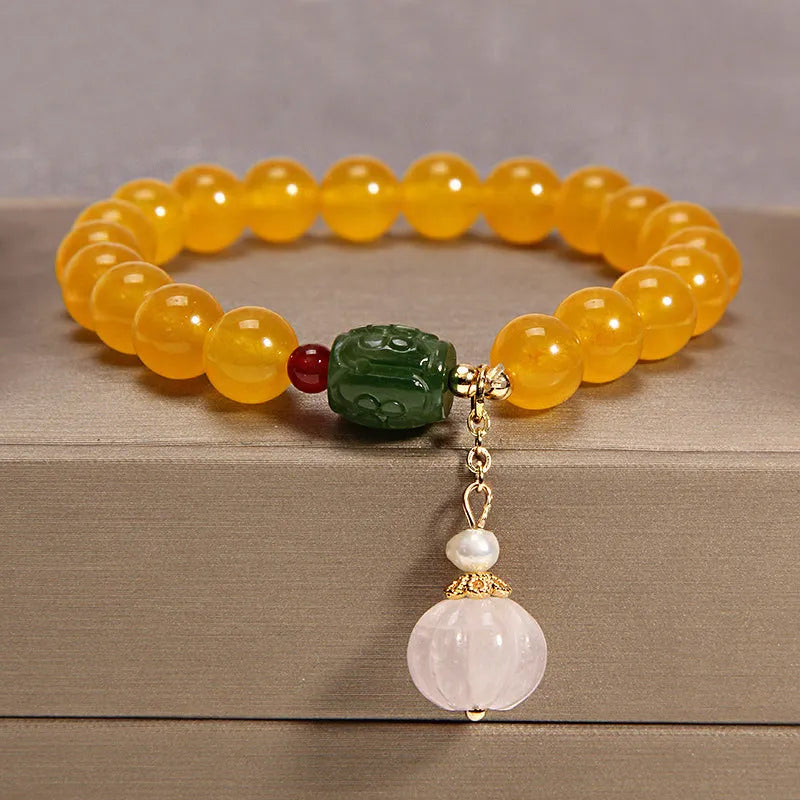 Women's yellow agate crystal bracelet with adjustable gold silk cord on wrist