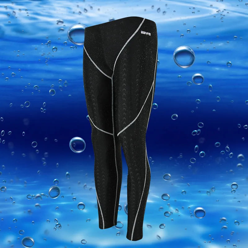 Men's nylon swimming trunks in black with grey trim, showing cropped brief style with mesh lining