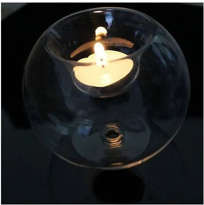 Handblown round hollow glass candle holder on a table, shown in frosted and clear finishes.
